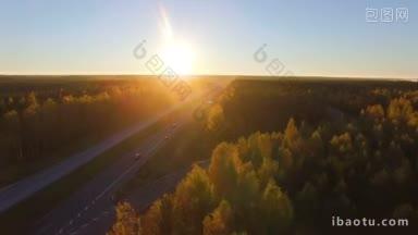 日落时高速公路的空中全景图，交通在阔叶林和针叶林之间